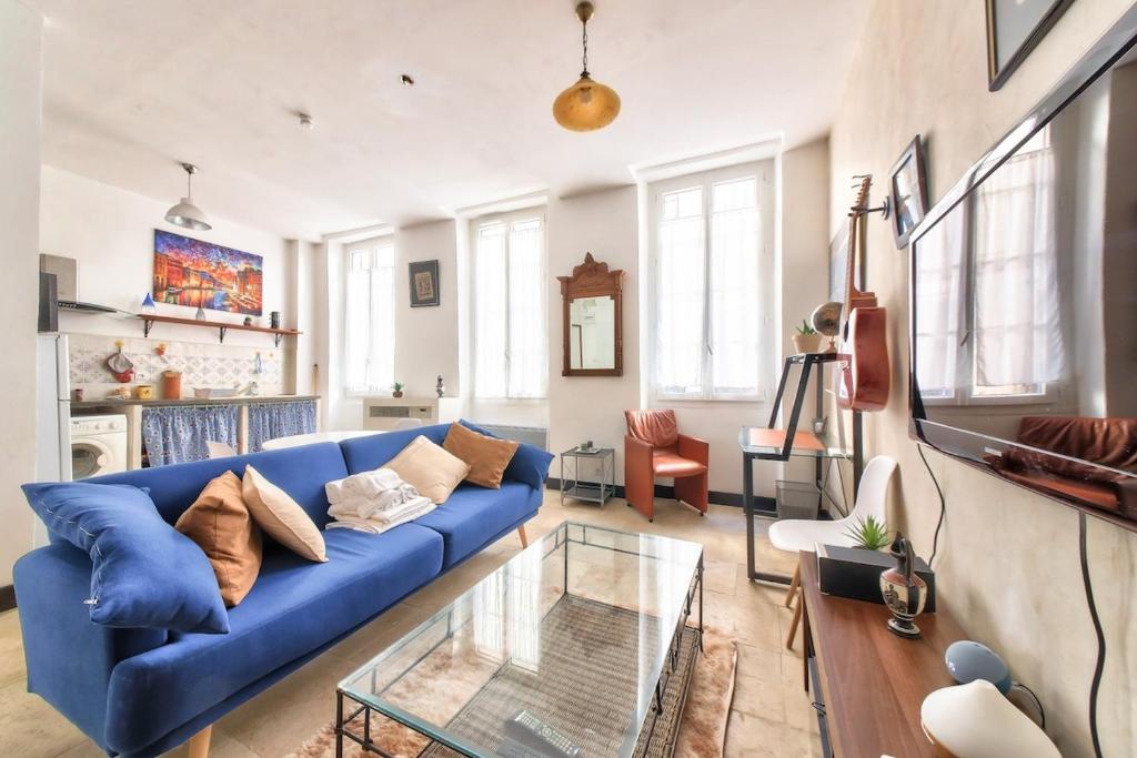 un salon avec un canapé bleu et une table en verre dans l'établissement Apartment Cosy Centre 3 pers, à Marseille