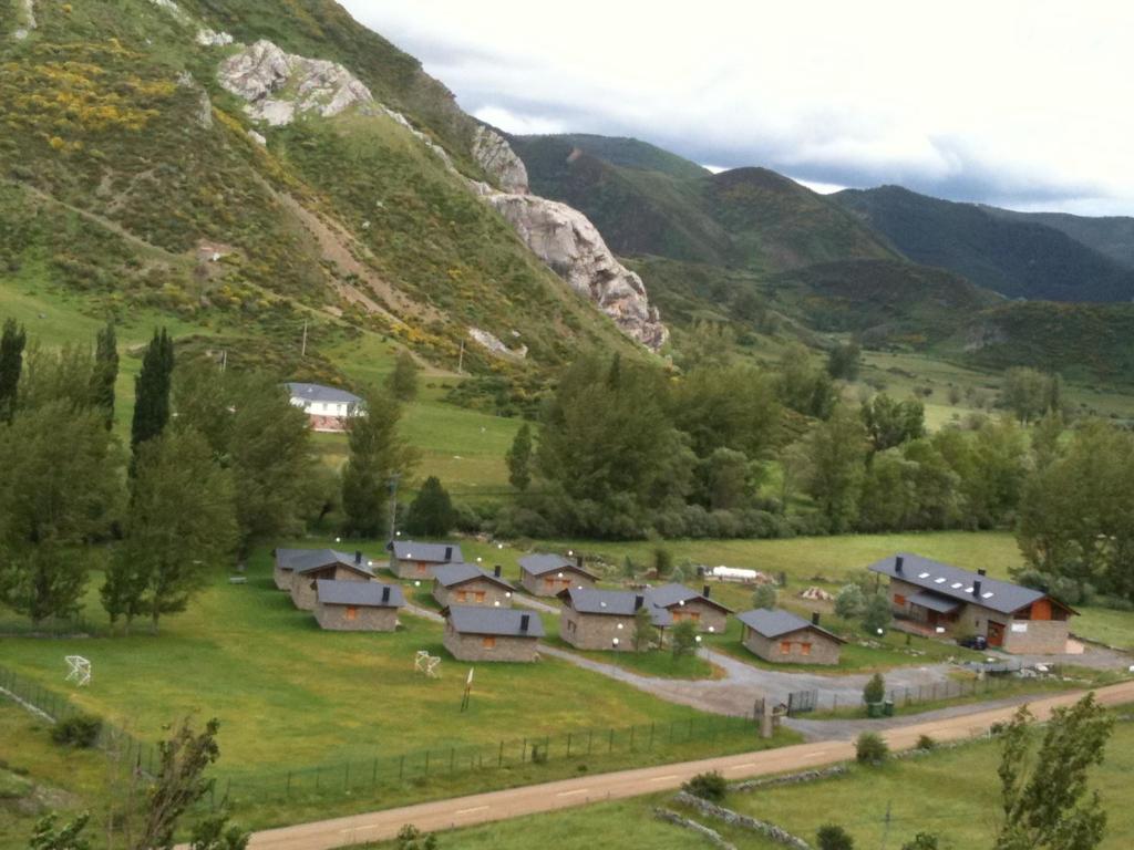 a village in a valley with mountains in the background at Casa de Montaña Alto Curueño in Lugueros