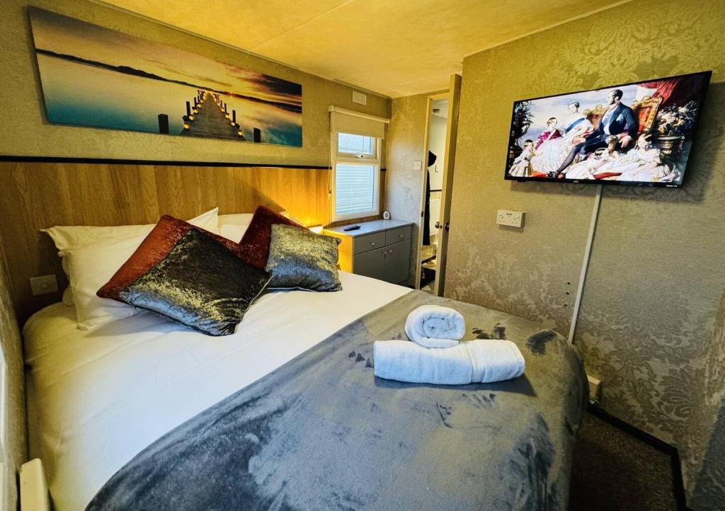 a hotel room with a bed with a towel on it at Golden Sands Holiday Home in Skegness