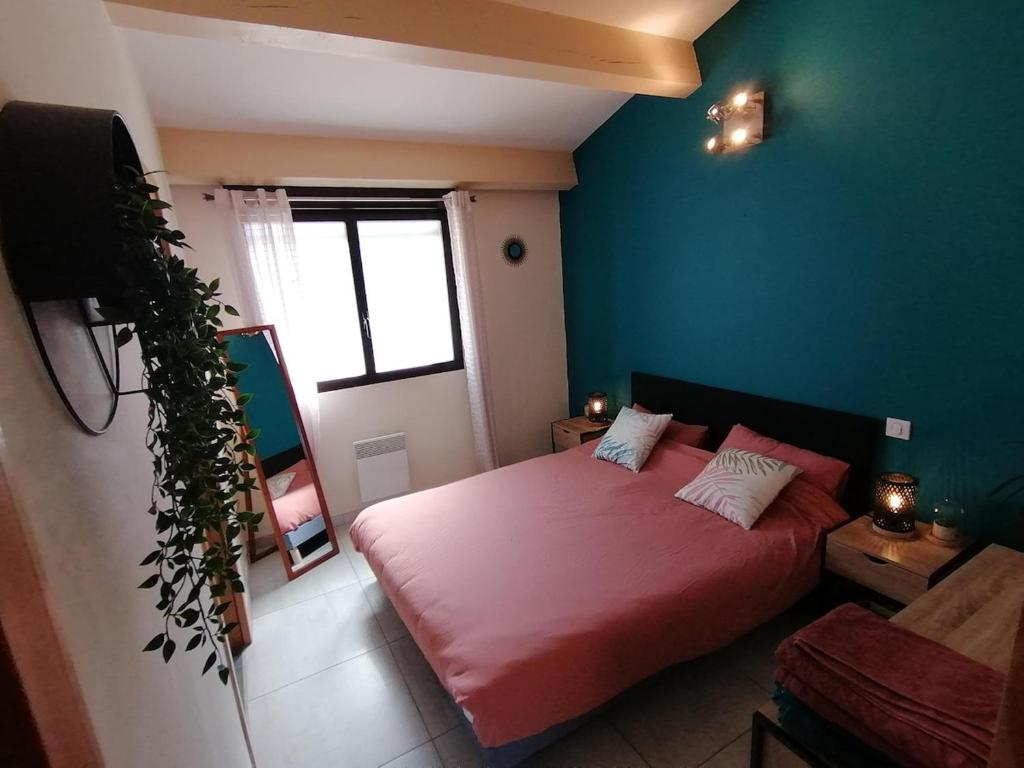 - une chambre avec un lit rose et un mur bleu dans l'établissement T3 Independant de 62 m2 au coeur du village, à Saint-Georges-dʼOrques