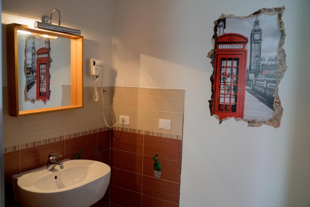 a bathroom with a sink and a red telephone booth at Coco'S Rooms in Bari Palese