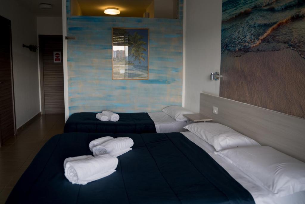 a room with two beds with white pillows at Coco'S Rooms in Bari Palese