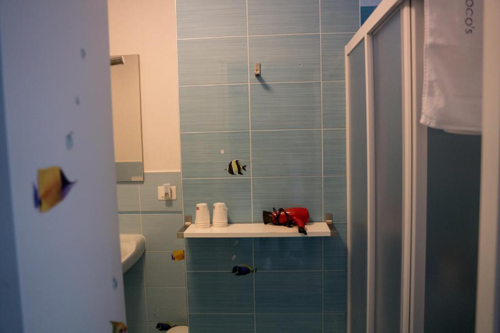 a bathroom with a blue tiled wall at Coco'S Rooms in Bari Palese