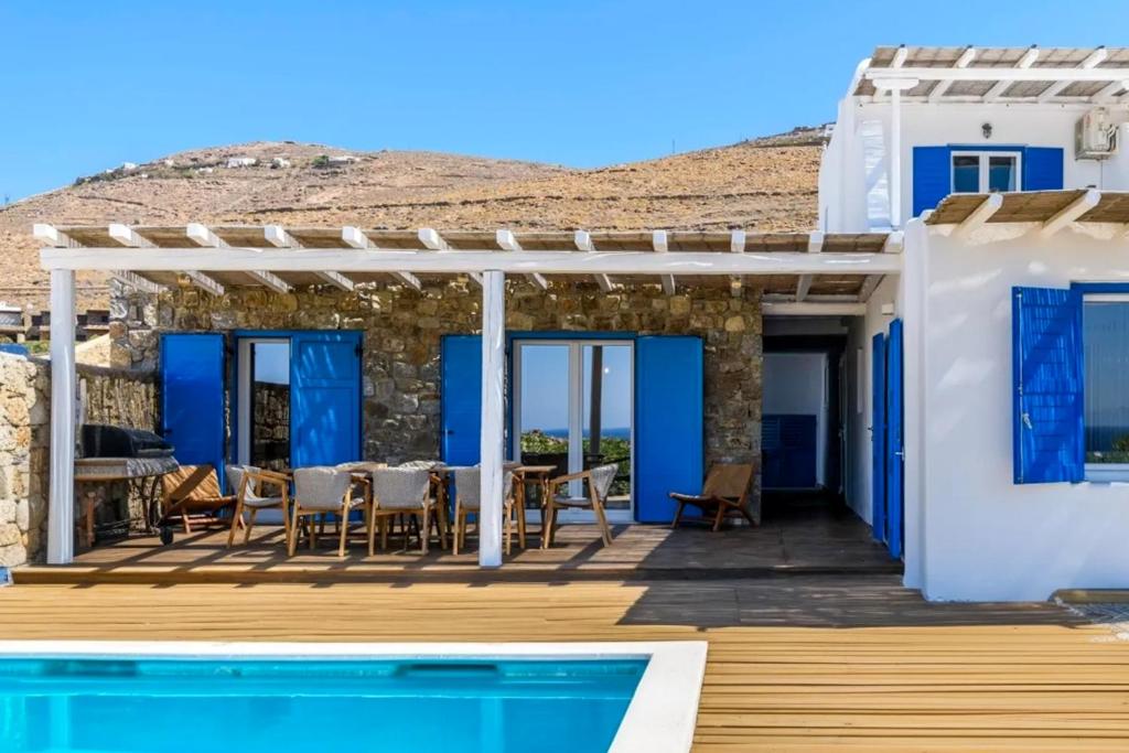 a villa with a swimming pool and a house at Emerald Bay 4BR with pool by Lia Beach in Mikonos