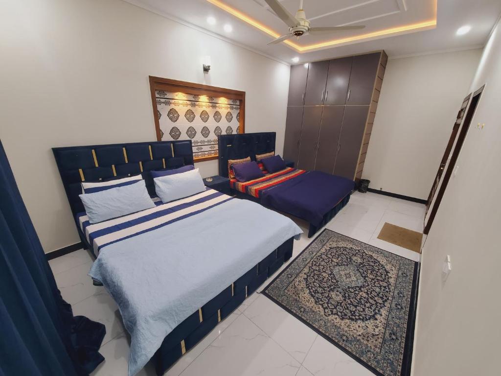 a bedroom with a king sized bed and a chair at Kashees Lodges in Islamabad