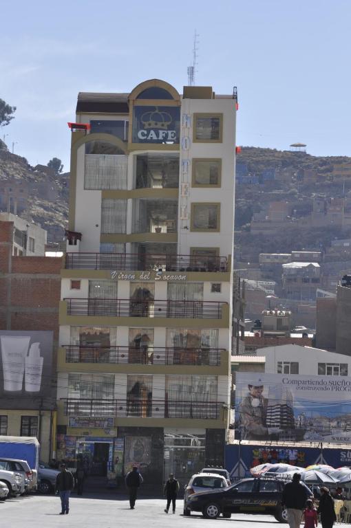 un edificio alto con macchine parcheggiate di fronte di Hotel "VIRGEN DEL SOCAVON" a Oruro