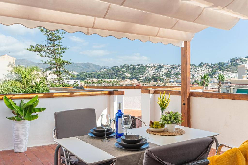 Una mesa y sillas en un balcón con vista. en Casa Lola Preciosa azotea vistas panorámicas, en Almuñécar