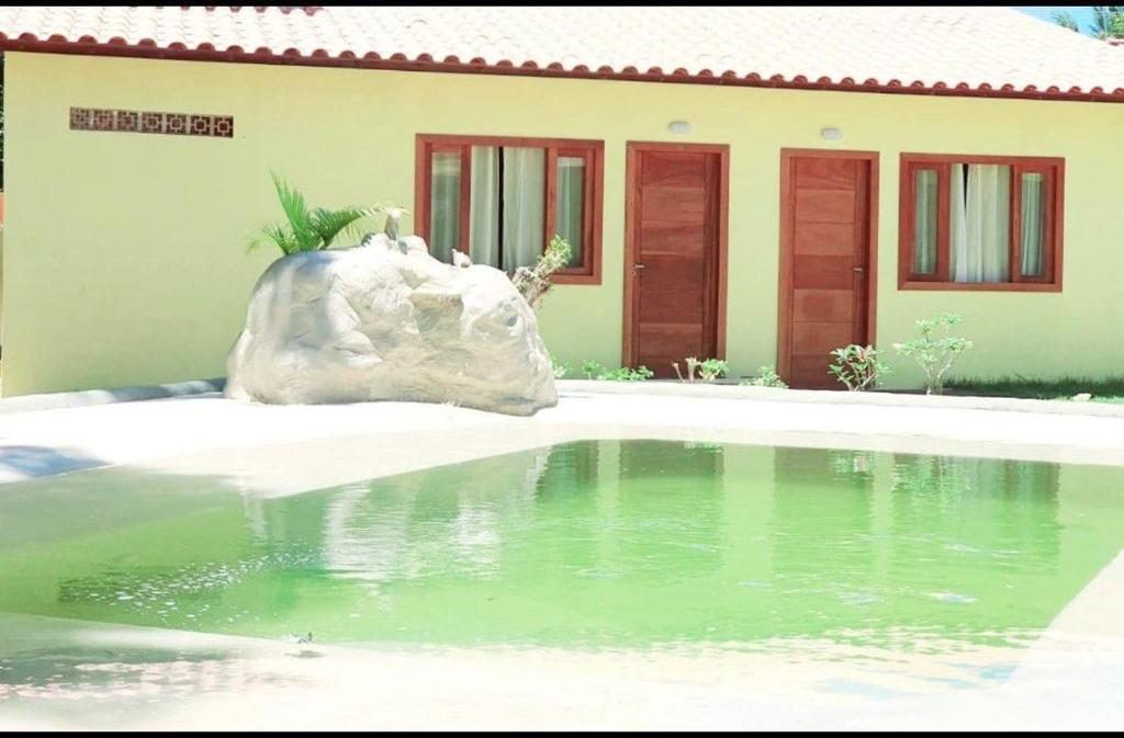 a small pool of water in front of a house at Suíte Santo in Santa Cruz Cabrália