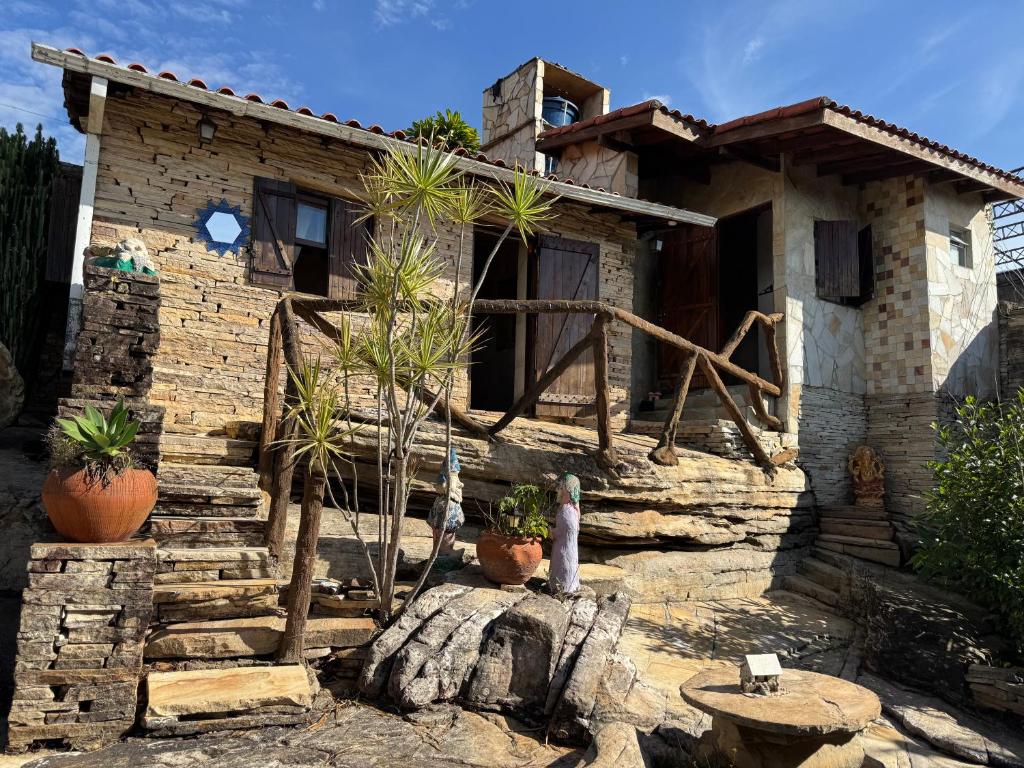 una casa in pietra con delle piante davanti di Pousada Morada do Soberano a São Thomé das Letras