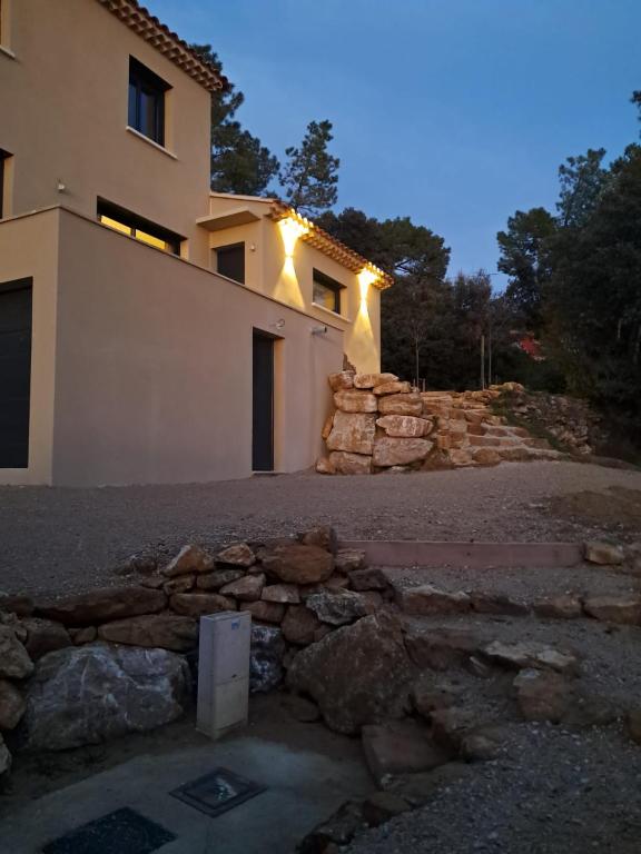 une maison avec un mur en pierre devant elle dans l'établissement Maison neuve climatisée, à 2 pas du centre de Bédoin, La Villa Thélo, à Bédoin