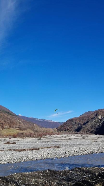 un hélicoptère survolant une rivière avec des montagnes en arrière-plan dans l'établissement Au bord de la rivière, à Digne-Les-Bains