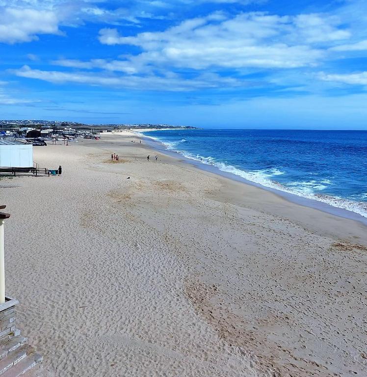 a beach with people on the sand and the ocean at Casa Maria T1 in Armação de Pêra