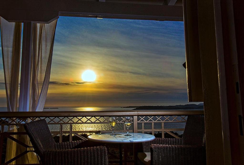 un balcone con tavolo e sedie, da cui potrete ammirare il tramonto. di Sunshine Resort a Lassi
