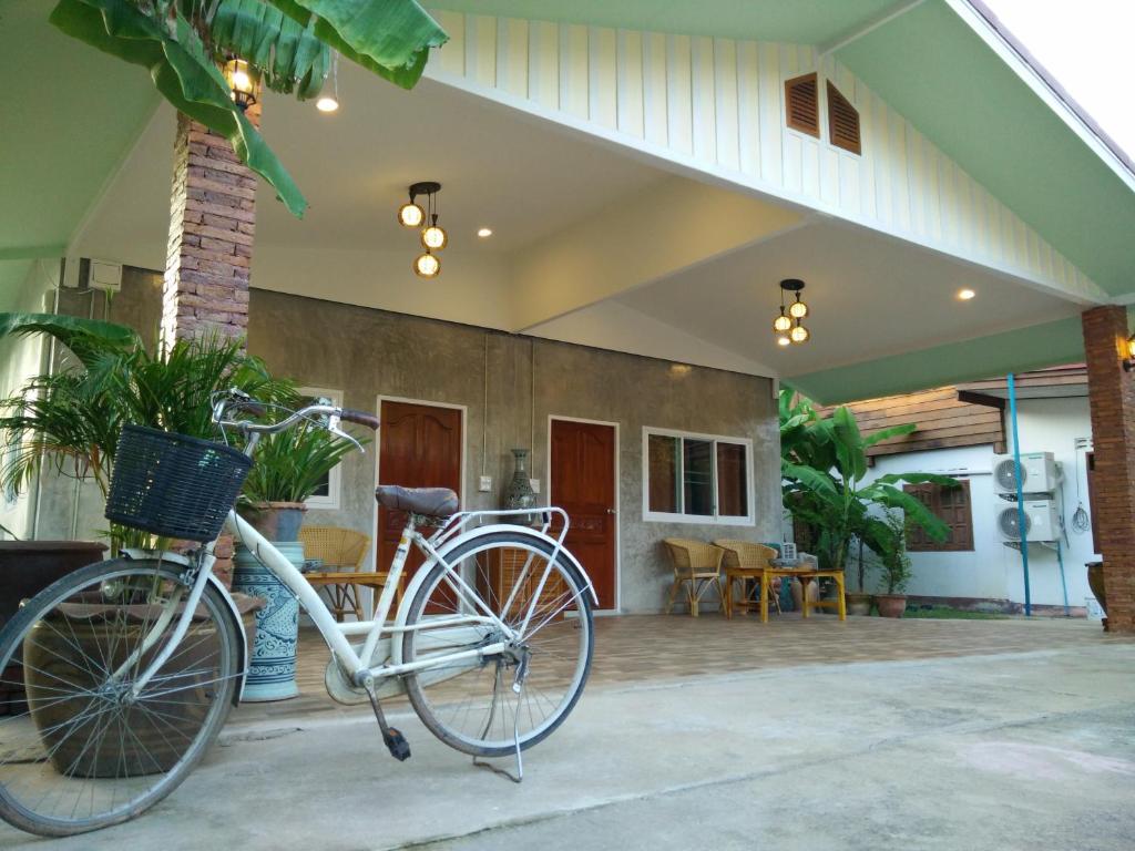a bike parked in front of a house at Pottery Street House in Sukhothai