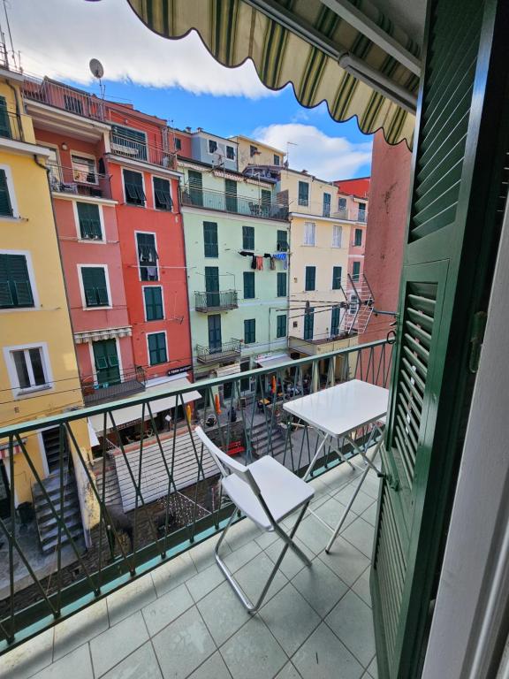 a balcony with a table and chairs and buildings at Bella Vernazza with AC and Balcony in Vernazza