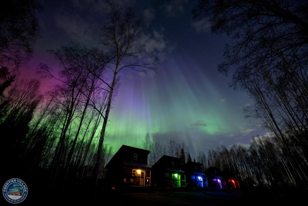 una casa con l'aurora boreale nel cielo di The Meandering Moose - Frontier Village a Fairbanks