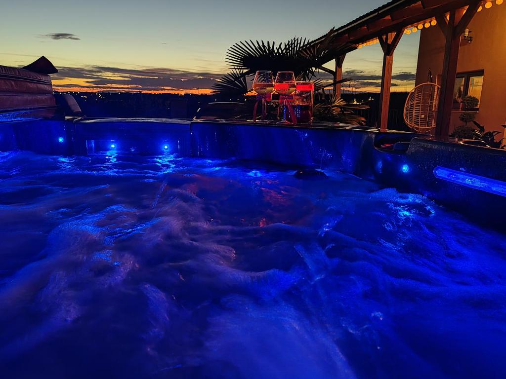 Un jacuzzi con luces azules en el agua. en Gímes Apartman, en Cserszegtomaj
