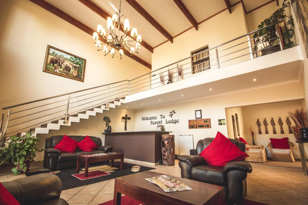 un vestíbulo con sofás y una escalera con almohadas rojas en Forest Lodge, en St Lucia