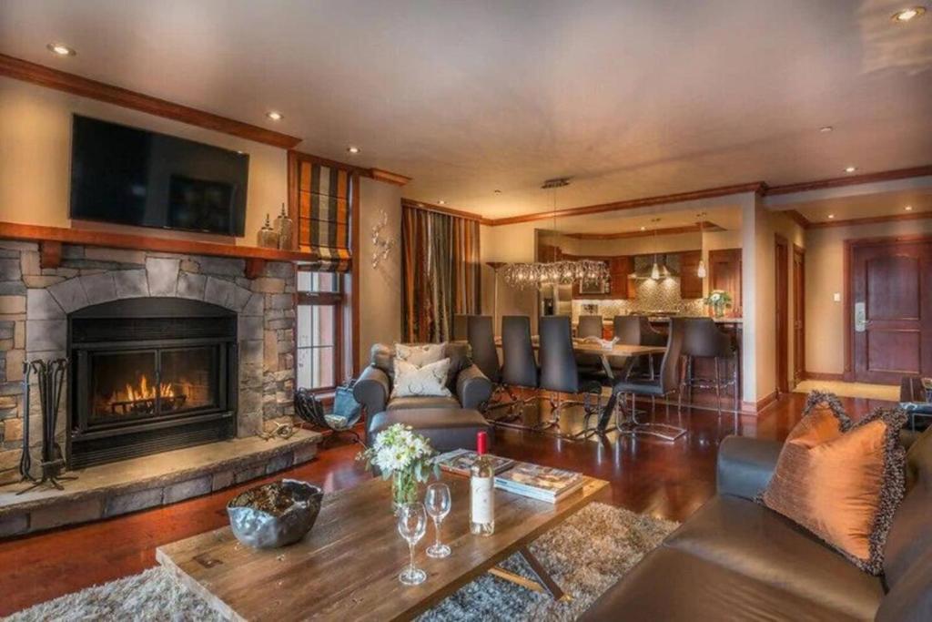 a living room with a fireplace and a table at Bondurant 95-8 Village at Doorstep in Mont-Tremblant