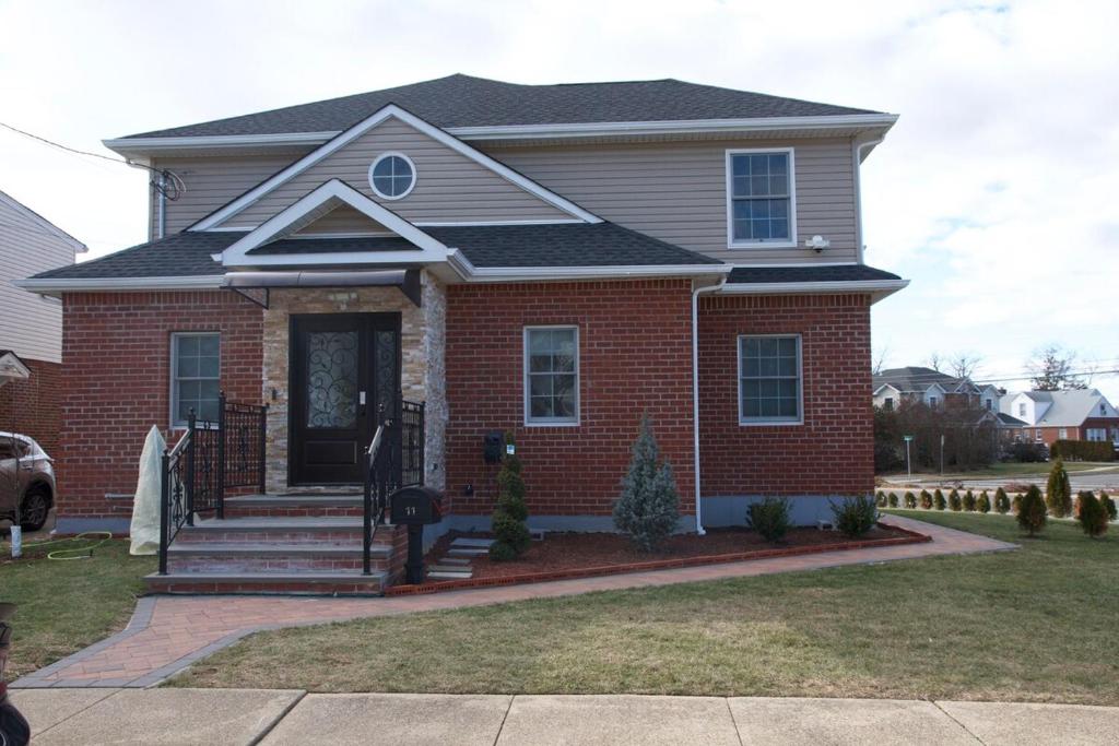 a red brick house with a black roof at 3 Bedroom Renovated Model House in New Hyde Park