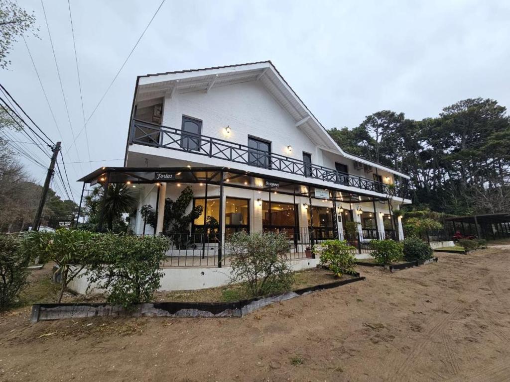 een groot wit gebouw met een balkon. bij Alamos Hosteria in Mar Azul