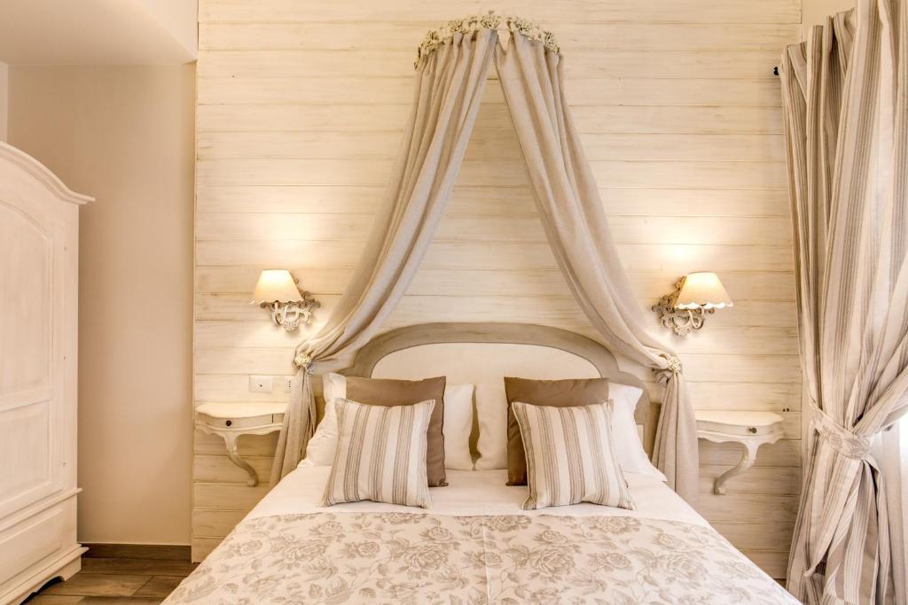 a bedroom with a white bed with a canopy at Casa Tua Vaticano Guest House in Rome