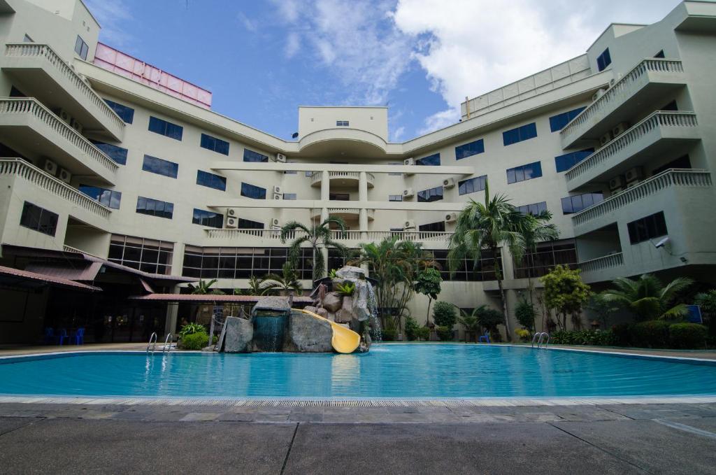 a swimming pool in front of a large building at Coral Bay Resort in Pangkor