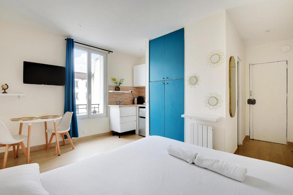une chambre avec un lit et une table et une cuisine dans l'établissement Charmant Studio Aubervilliers, à Aubervilliers