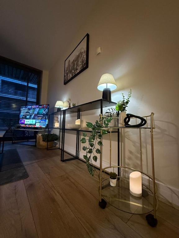 sala de estar con mesa de cristal y maceta en 2 bedroom Titanic Apartment - 1 night stays!, en Belfast