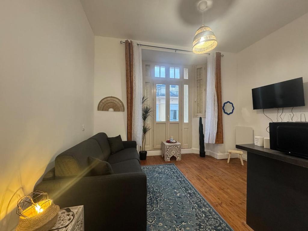 un salon avec un canapé et une télévision à écran plat dans l'établissement Le Marrakech - Studio, à Vichy