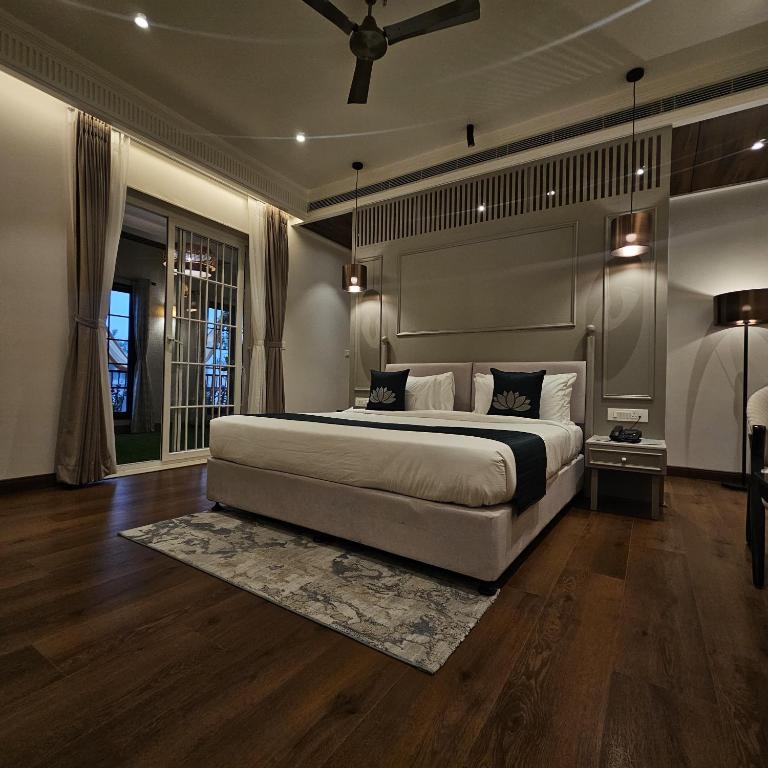 a bedroom with a large bed and a ceiling fan at Narayan Kothi in Varanasi