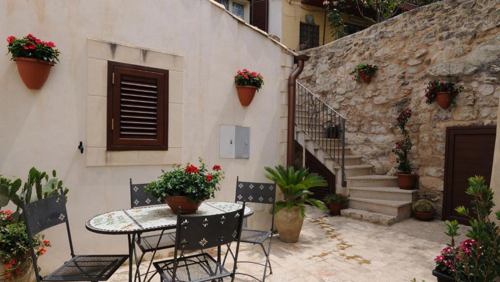 a patio with a table and chairs and a staircase at Bed & Breakfast Scicli in Scicli