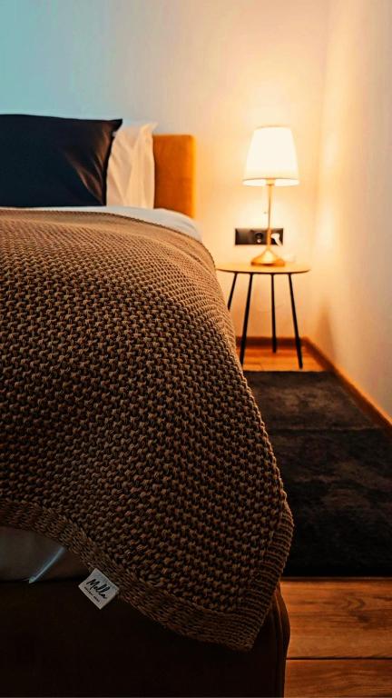 StrahoninecにあるMella holiday homeのベッドとランプ付きのテーブルがある寝室