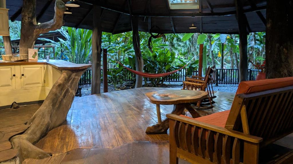 a large wooden table with benches and a table with a tree at Tree House Beachfront Lodge in Puerto Viejo