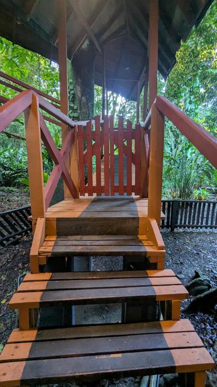 a wooden bench sitting under a gazebo at Tree House Beachfront Lodge in Puerto Viejo