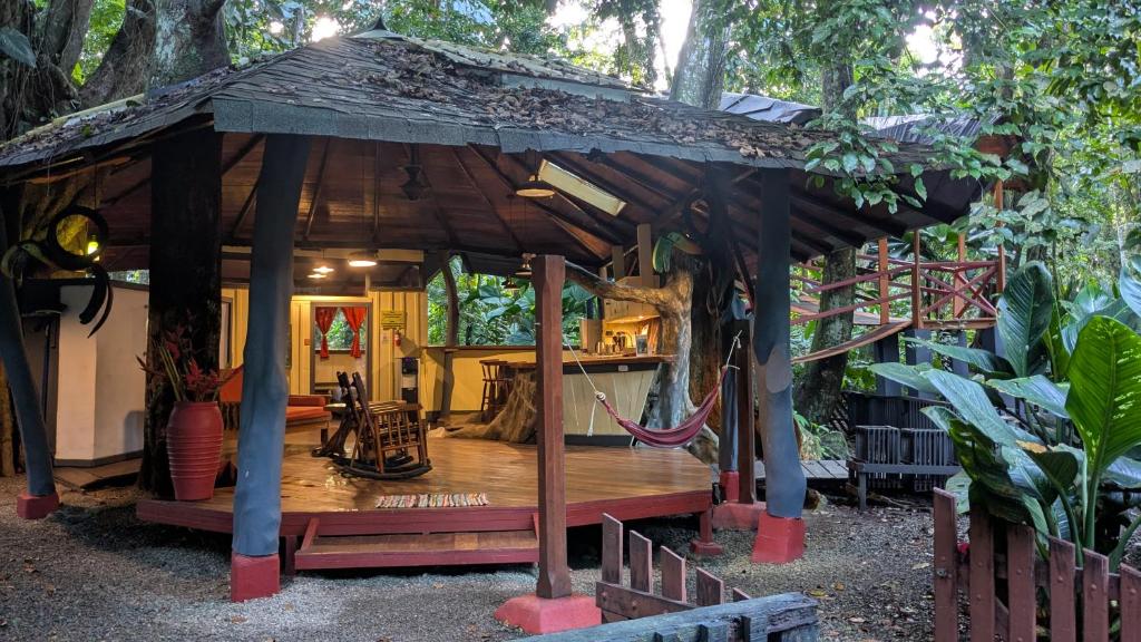 a wooden pavilion with a hammock in a garden at Tree House Beachfront Lodge in Puerto Viejo