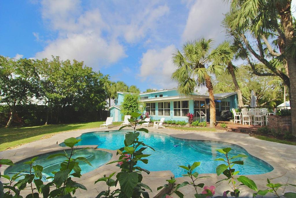 a house with a swimming pool in front of a house at Pelicans Landing in Stuart