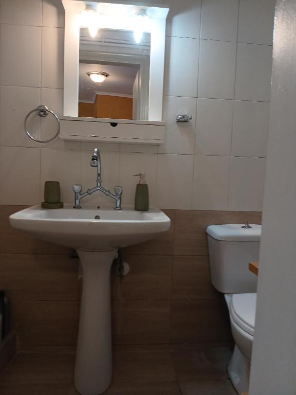 a bathroom with a sink and a toilet and a mirror at Athina in Thessaloniki