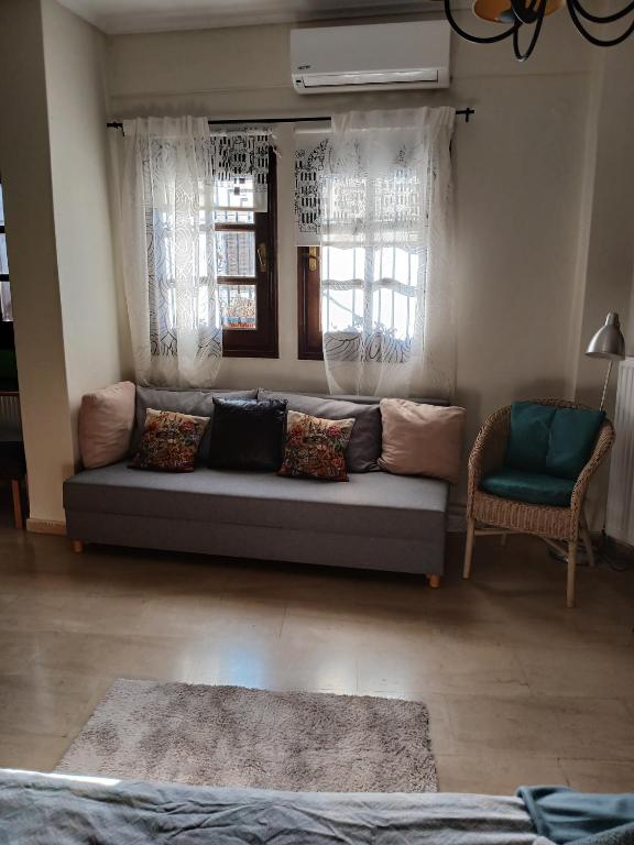 a living room with a couch and two windows at Athina in Thessaloniki