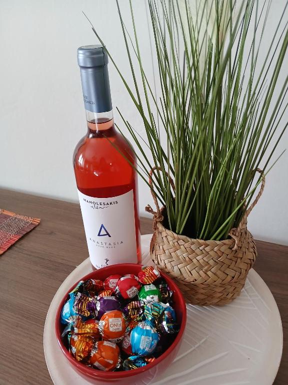 a bottle of wine next to a bowl of candy at Athina in Thessaloniki