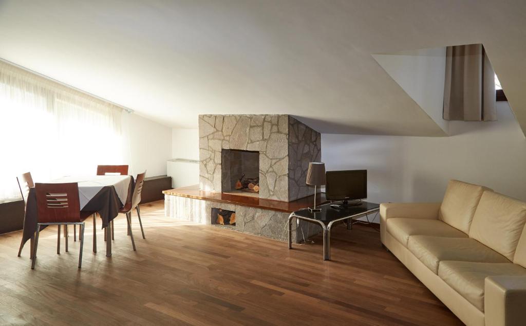 a living room with a couch and a fireplace at Green Garden APARTMENTS in Chirignago