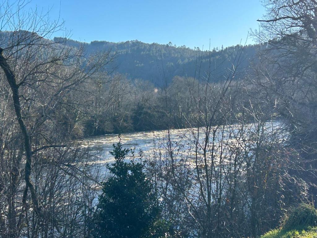 une rivière avec de la neige et des arbres au premier plan dans l'établissement Le temps des gabariers, à Monceaux-sur-Dordogne