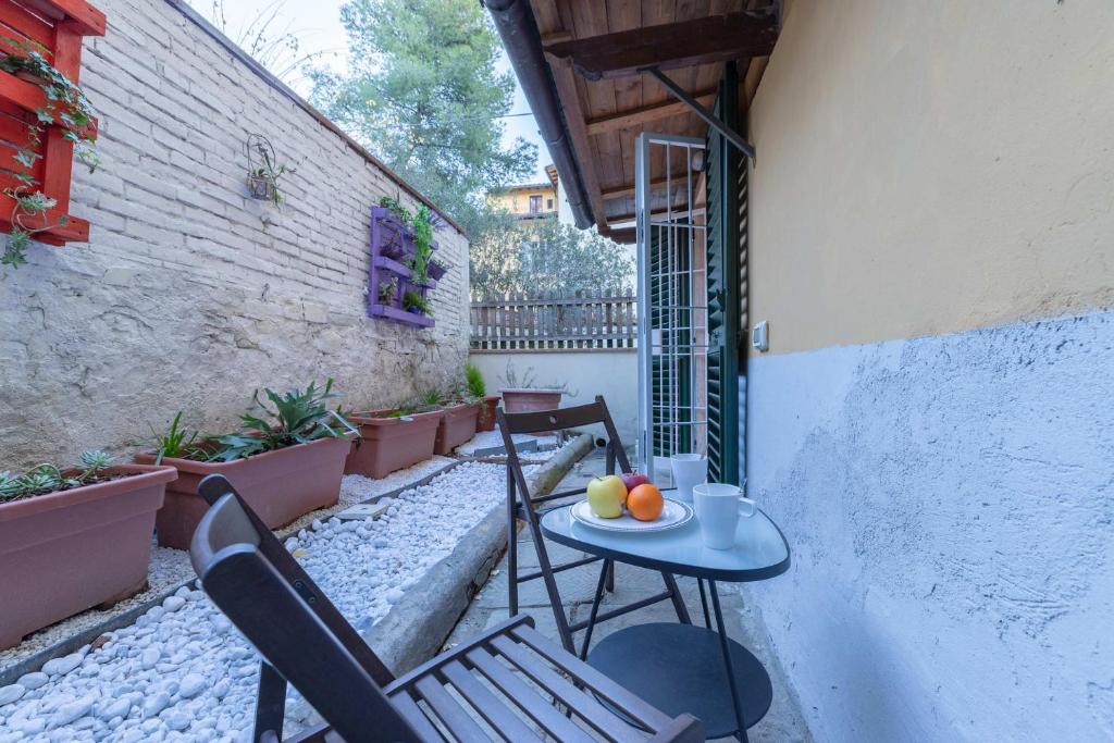 un patio con due sedie e un tavolo con frutta di S.Ambrogio Courtyard in Florence-hosted by Thinah a Firenze