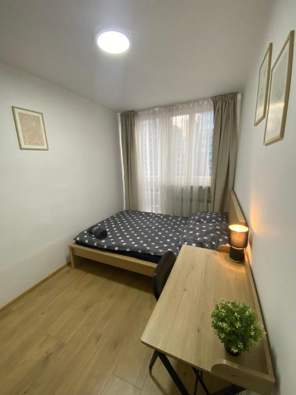 a small room with a bed and a table at Rooms in Warsaw - G39 in Warsaw