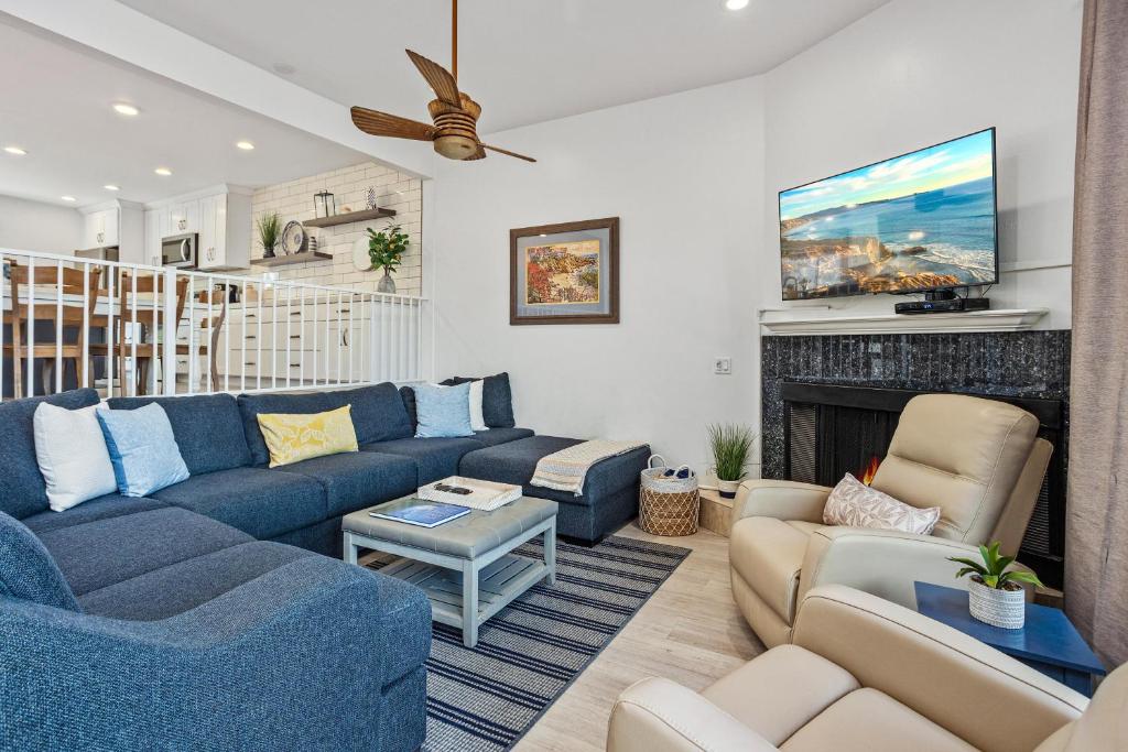 a living room with a blue couch and a fireplace at Live in the Sunshine-DMBC148N in Solana Beach