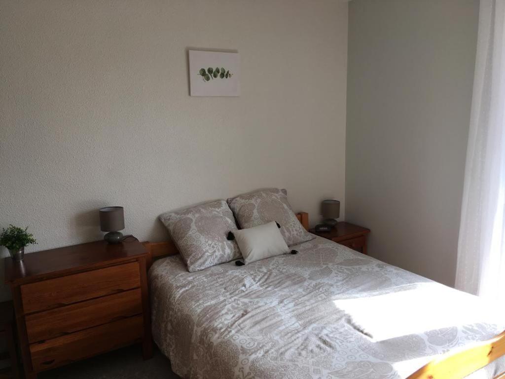 ウジェニー・レ・バンにあるLes Alisiers 26のベッドルーム1室(ベッド1台、ナイトスタンド2台、枕1台付)