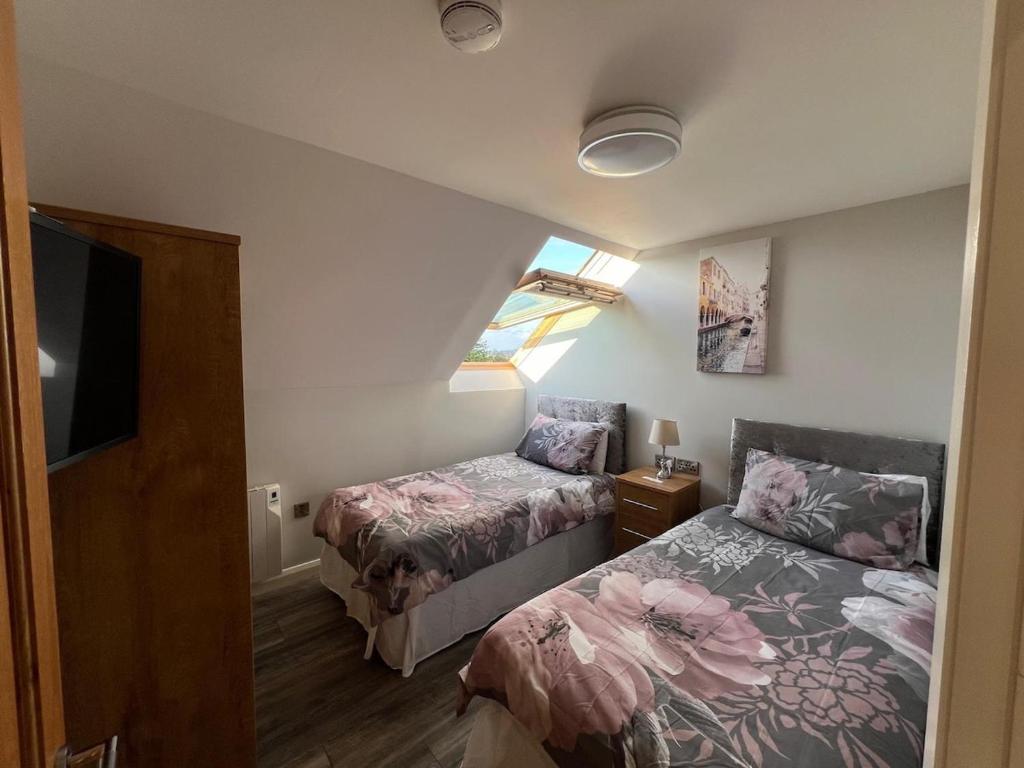 Sion MillsにあるThe Mill Luxury Loft Sion Millsの小さなベッドルーム(ベッド2台、テレビ付)