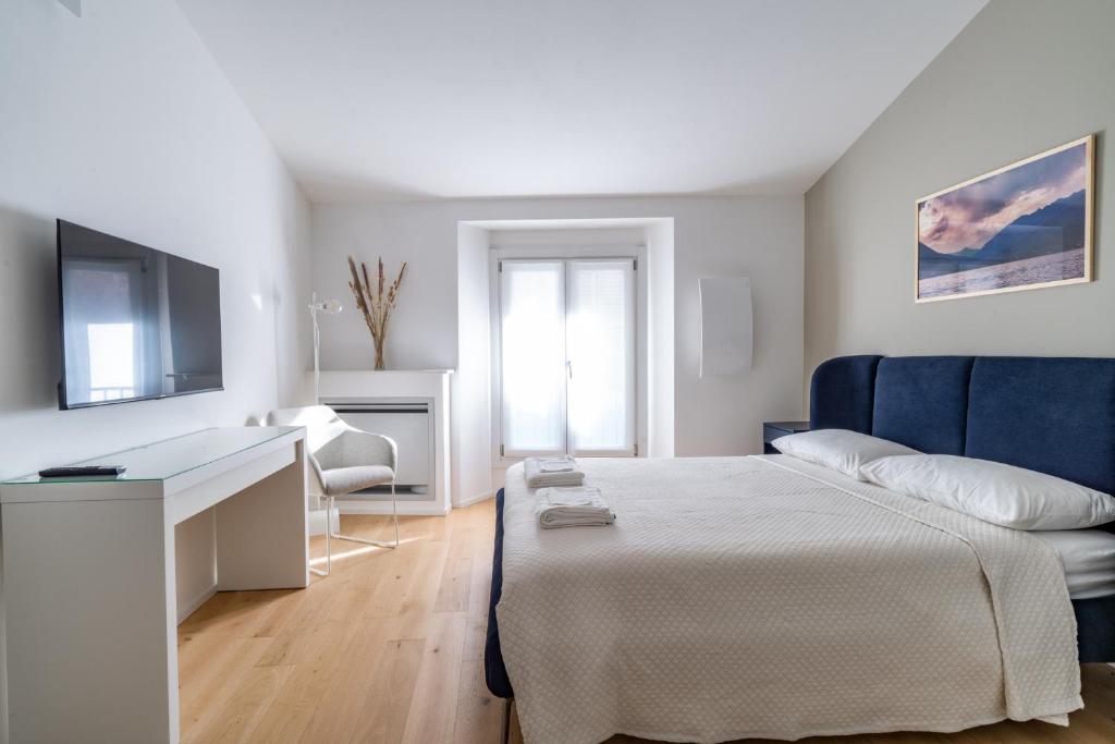 a bedroom with a bed and a desk and a television at Cà del Lago in Arona