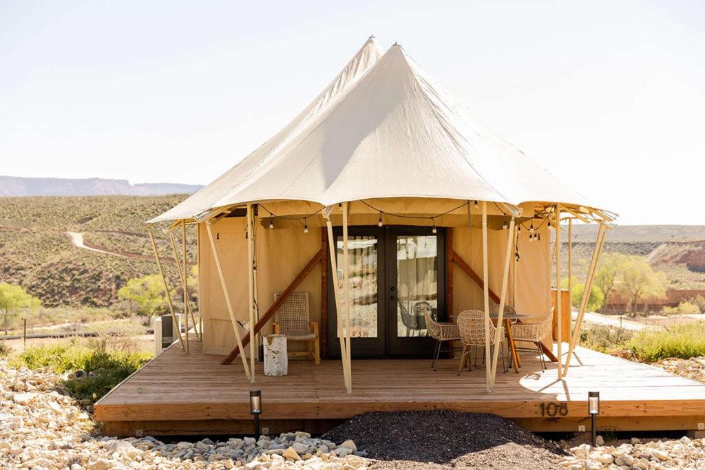 a tent on a wooden deck in the desert at Zion Wildflower Resort in Virgin