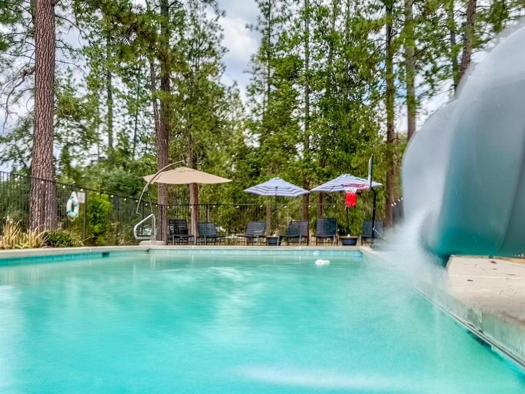 a swimming pool with a water fountain at Pool-GameRoom-HomeTheater-Bar-PlayStructure-FirePit in Oakhurst
